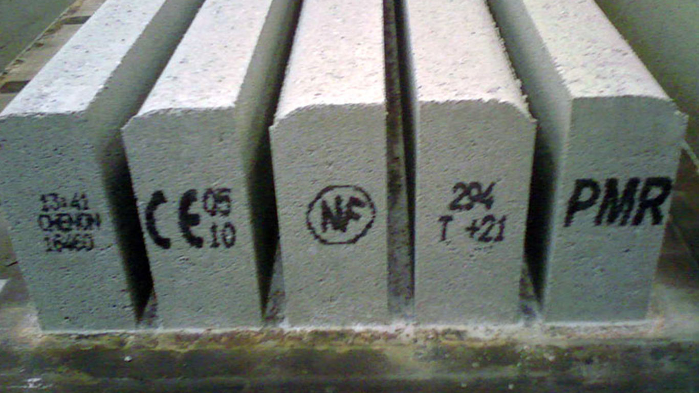 Marquage industriel jet d'encre sur bordures en béton : Date, Code, lot, Classe, Nom Fabricant, Marquage CE, logo NF