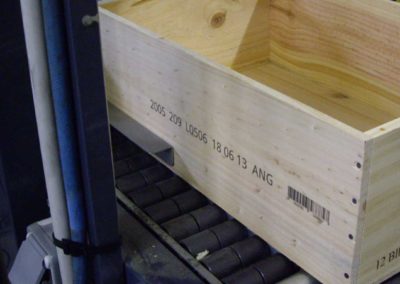 Marquage sur caisse de bouteilles en bois - Impression sur convoyeur des caisses bois à 20 m/min, marquage haute définition sur une ligne, date, code, lot et code barres.