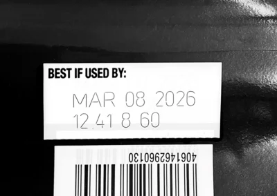 Exemple de marquage laser industriel de date limite sur emballage plastique noir
